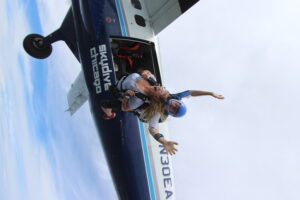 checking skydiving off the bucketlist as tandem skydiving pair exits plane from 13,500 feet