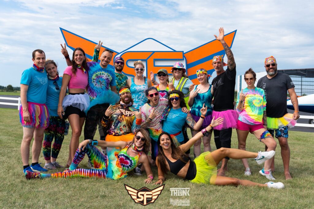 Summerfest boogie participants pose in front of the event logo at Skydive Chicago