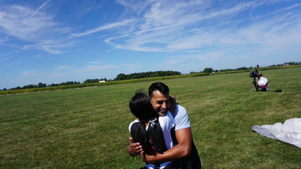 Tandem skydivers hug after their first jump at Skydive Chicago